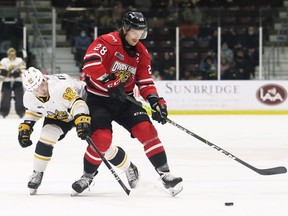 Owen Sound Attack's Mark Woolley, right, is checked by Sarnia Sting's Nikita Tarasevich in the first period at Progressive Auto Sales Arena in Sarnia, Ont., on Sunday, Nov. 21, 2021. Mark Malone/Chatham Daily News/Postmedia Network