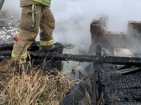 Chris Chudyk, a volunteer firefighter with Brant County Fire, created billows of steam Sunday as he worked to hose down a deliberately set basement fire on Burtch Road.