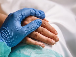 A healthcare worker comforts a patient in hospital