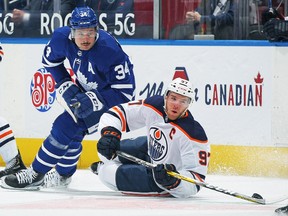Connor McDavid of the Edmonton Oilers battles for the puck against Auston Matthews of the Toronto Maple Leafs at Scotiabank Arena on March 29, 2021 in Toronto.