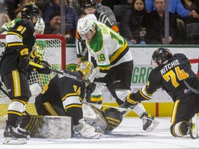 Colton Smith of the London Knights tries to jam a loose puck under Anson Thornton of the Sarnia Sting with Ethan Ritchie on the ice and Max Namestnikov of the Sting also moving in during the first period at Budweiser Gardens in London, Ont., on Friday, November 19, 2021. Mike Hensen/The London Free Press/Postmedia Network