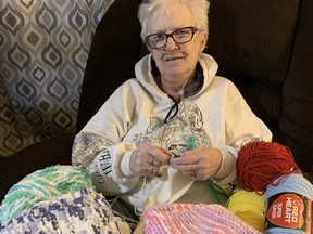 Sue McNeil has a giant bin of yarn, busy knitting needles and a desire to help others, despite her own serious medical issues.