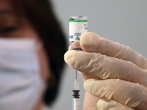 File: A healthcare worker prepares a dose of vaccine against Covid-19