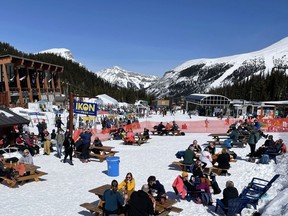 Skiers and snowboarders relax in the sun in the outdoor seating area at Mad Trapper's Saloon Banff Sunshine Village in April, 2021. Sunshine Village said they are able to operate at full capacity on lifts and indoors this season, which is much closer to normal than last season. Photo Marie Conboy/ Postmedia.