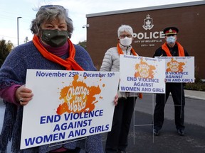 Sandy Watson-Moyles, left, of Three Oaks, Sharon Vanclief of the Grandmothers Advocacy Network and Chief Mike Callaghan of the Belleville Police Service hold signs Monday outside police headquaters to promote the United Nations 16 Days of Activism to End Gender-Based Violence. It's a global effort to reduce violence against women, something that has increased during the pandemic.