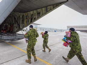 Members from the Canadian Armed Forces carry donated toys into the back of a RCAF airplane at 8 Wing Trenton for the Toys for the North initiative. Tuesday in Trenton, Ontario. ALEX FILIPE