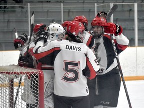 The Picton Pirates surround goaltender Nolan Lane after a 3-2 win in Amherstview on Sunday.