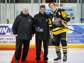 Dalton Bancroft of the Trenton Golden Hawks receives the South-East Conference Warrior hockey player of the month for award (October) from Rob Macgregor (centre), director of officiating and John Macdonald, director of hockey operations for the Golden Hawks at the Duncan McDonald Memorial Gardens oFriday night. Amy Deroche / OJHL Images