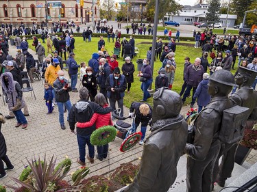 As the crowd disperses at the conclusion of Remembrance Day ceremonies in Brantford, some linger to take photographs or place poppies on wreaths on Thursday November 11, 2021. Brian Thompson/Brantford Expositor/Postmedia Network