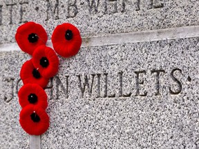 Relatives of John Willets placed their poppies around his name on the Brant County War Memorial at the conclusion of Remembrance Day ceremonies on Thursday November 11, 2021 in Brantford, Ontario. Brian Thompson/Brantford Expositor/Postmedia Network