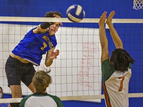 Will Ford of the BCI Mustangs watches his spike go past a block attempt by Kelvin Ngo of the North Park Trojans during a senior boys volleyball semi-final match on Thursday.