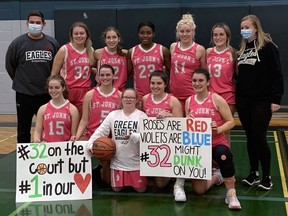 Members of the St. John's College senior girls basketball team pose with manager Kailee Mitchell (white shirt) after she appeared in the team's semifinal game on Thursday against Pauline Johnson Collegiate.