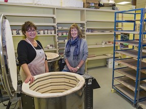 Norfolk Potters' Guild executive members Mary Whitehead (left) and Nancy Brown stand by one of three kilns in the guild's new home at 60 First Avenue in Simcoe on Saturday.