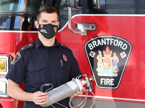 Fire prevention officer Mike Owen holds a medical oxygen tank.