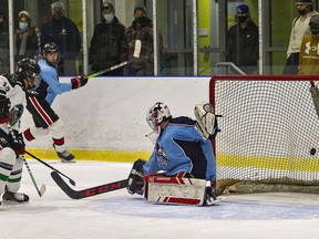 Evano Planamente of the St. John's Eagles watches his shot beat Assumption Lions goalie Justin Floresco to give the Eagles a 1-0 lead during a high school boys hockey game on Thursday at the Wayne Gretzky Sports Centre in Brantford.