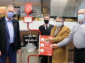 Brantford Mayor Kevin Davis (left), Maj. Darrell Jackson of the Salvation Army of Brantford and Paris, Brant Mayor David Bailey and Keith Harvey, manager of the Sobeys store in West Brant, check out the "tap to give" feature at the Christmas kettle kickoff on Thursday.