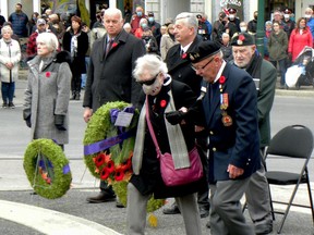 Silver Cross Mother Sally Hughes prepares to lay her wreath at Brockville's Remembrance Day ceremony, assisted by Barry Elliott of the Royal Canadian Legion, Branch 96, while her husband, Ted Hughes (back, right) looks on with Mayor Mike Kalivas, Doug Brewer from MPP Steve Clark's office and Barbra Wilkinson, representing MP Michael Barrett. (RONALD ZAJAC/The Recorder and Times)