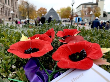People walk among the pre-laid wreaths behind Brockville's cenotaph after Thursday morning's Remembrance Day ceremony. (RONALD ZAJAC/The Recorder and Times)