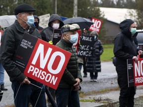 North Grenville residents carry 'No Prison' signs while they protest at the site of a proposed correctional facility on Kemptville Campus land on Saturday.