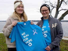 From left, Vanessa and Alanna Lasenba pose at Cunningham Park on Wednesday with one of the T-shirts for Saturday's Canadian Cancer Society fundraiser. (RONALD ZAJAC/The Recorder and Times)