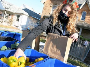 Heather Tulloch, community food connector with the Chatham-Kent Prosperity Roundtable, loads up a bag of fresh produce at the Mobile Market stop at Hope House in Chatham on Dec. 3, 2020. Tom Morrison/Chatham This Week