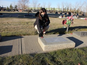 École Leduc Junior High School student Cassidy Tremblay lays a poppy on a headstone at the Leduc Municipal Cemetery Nov. 2. (Ted Murphy)