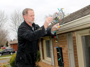 Jeff Randall took advantage of the mild weather earlier in the day on Saturday to put up Christmas lights on his south Chatham home ahead of the snow forecasted for later in the day. ELLWOOD SHREVE PHOTO/Chatham Daily News/Postmedia