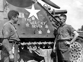 Bombardiers D. Nashawa of the Saugeen First Nation and G. Harper in 'A' Troop of the 19th Field Regiment pose by a Priest self-propelled gun called the "Wacky Seven." Courtesy of Peter Brown and Library and Archives Canada; Greg Colgan, 19th Field Regiment, RCA Facebook page