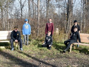 Some Grade 6 students at St. Columban school sit on some of the wooden benches that can easily convert into work stations at their "forest" which is owned by the St. Columban Soccer Club. ANDY BADER