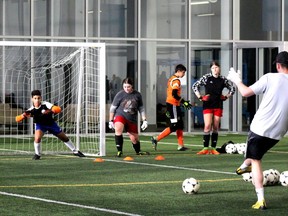 A keeper dives to stop Dylon Powley from scoring during a two-day goalkeeping camp at Shell Place on Sunday, November 28, 2021. Laura Beamish/Fort McMurray Today/Postmedia Network