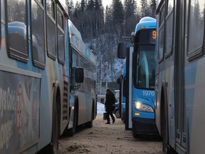 A commuter walks between buses at the Main Terminal in downtown Fort McMurray, Alta. on Tuesday February 17, 2015. Vince Mcdermott/Fort McMurray Today/QMI Agency ORG XMIT: POS1607151119132443