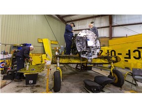 Harvard association of Canada volunteers Mel Ralph, Wayne Buchanan and William Wright work on a torn-down Second World War era Harvard they are rebuilding at their association headquarters at Tilsonburg airport. Photograph taken on Tuesday, Nov. 2, 2021. (Mike Hensen/The London Free Press)