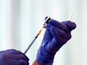 A medical worker fills a syringe with a dose of the Pfizer-BioNTech coronavirus disease (COVID-19) vaccine .
