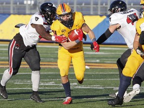 Queen's Gaels running back Burke Derbyshire avoids a tackle from Carleton Ravens linebacker Darren Kyeremeh (34) during Ontario University Athletics East semifinal football action at Richardson Stadium in Kingston on Saturday. The Gaels won the game, 41-14.