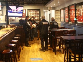 Kingston Police and Enforcement Officers from the Sheriff's Office serve J.A.K.K. Tuesdays Sports Pub with a Section 22 court order directing the restaurant to adhere to COVID-19 protocols relating to immunization passports in Kingston on Wednesday.