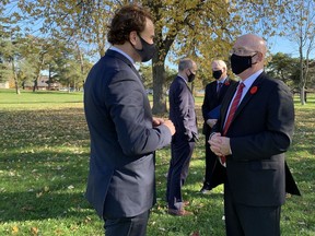 David Howard of Homes for Heroes talks with Steve Clark, provincial minister of municipal affairs and housing, after Wednesday's announcement about a tiny homes development for homeless veterans in Kingston.