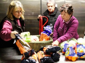 In this photo from 2017, Gananoque Food Bank volunteers Joanne Lancaster, Patricia Watts and Gwen Hundrieser prepare a basket of food for distribution. Gananoque Food Bank is hoping that people will be willing to participate in this yearÕs Reverse Advent Calendar campaign to increase donations over the month of December.   
Lorraine Payette/For Postmedia Network