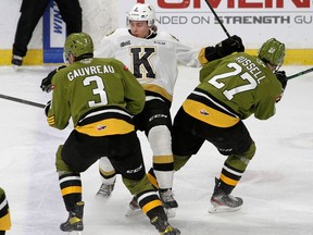 Kingston Frontenacs' Gage Heyes gets hit between North Bay Battalion's Cam Gauvreau and Mitchell Russell in Ontario Hockey League action at the Leon's Centre in Kingston on Friday, Nov. 26, 2021.