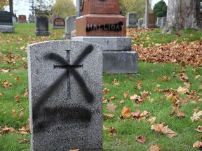 Spray-painted headstones on West Avenue at Cataraqui Cemetery seen Thursday.