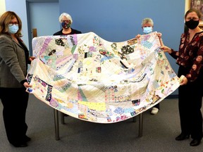 This stunning Second World War Red Cross patchwork quilt has been repatriated to Gananoque from Britain. L-r, Joanna Dermenjian (researcher); Marian McLeod (church); Deirdre Crichton, and Pam Hudson (library).  
Lorraine Payette/For Postmedia Network