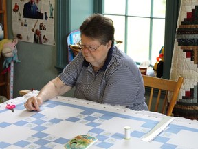 Velma Kelsey working at a quilting table/frame in 2011. Women would gather at tables such as this to make the quilts that were donated to the Red Cross and the War Effort during The Second World War when more than 250,000 quilts were produced in Ontario and donated to those overseas who were in need.   
Lorraine Payette/For Postmedia Network