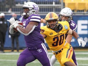Western Mustangs' Keon Edwards runs for a touchdown past Queen's Gaels' Josh McBain during the Ontario University Athletics football final at Richardson Stadium on Nov. 20, 2021.