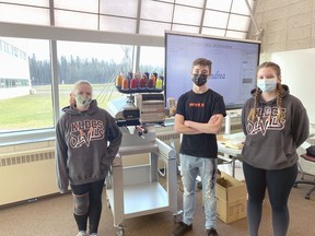 KLDCS students Andrea Delport, Joe McInnis and Danika Fey spent time recently being trained on the school's new Melco embroidery machine in the Greenhouse.