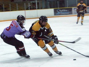 Exeter Hawk Carter Bowerman tries to hold off a North Middlesex player during Exeter's 6-5 overtime victory Tues., Nov. 23.