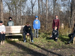 Some Grade 6 students at St. Columban school sit on some of the wooden benches that can easily convert into work stations at their "forest" which is owned by the St. Columban Soccer Club. ANDY BADER/MITCHELL ADVOCATE