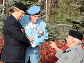 Lynn Mathieson (left) of the Petawawa Legion Ladies Auxiliary escorts veteran Irvin "Curly" Andrews to his seat at the Petawawa cenotaph ahead of the Remembrance Day Ceremony on Nov. 11. They are chatting with veteran James Mackenzie of Petawawa.
