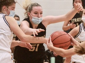 Stratford and District secondary school player Morgan Goffar (51) lunges at a loose ball in front of St. Mike’s opponents Alexis Hinds (5) and Faith Vito, far right, during the Huron-Perth senior girls’ basketball game Wednesday afternoon. SDSS won 27-26