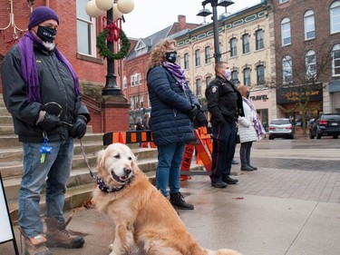 Fred Buck (and Gord), Lisa Wilde, and Stratford Police const. Darren Fischer were part of a human chain formed around Stratford's city hall on Thursday in recognition of the International Day for the Elimination of Violence Against Women. Chris Montanini/Stratford Beacon Herald/Postmedia News