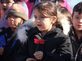 Meira Plain, 4, joins other children from Aamjiwnaang Day Care singing O Canada at a remembrance service held Monday, National Indigenous Veterans Day, at the First Nation's cenotaph.