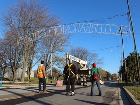 Volunteers with the Celebration of Lights watch as a crane moves into position to finish raising the candle arch display into position Friday morning on Front Street in Sarnia. This year's holiday lights display in Centennial Park is scheduled to begin Dec. 1.